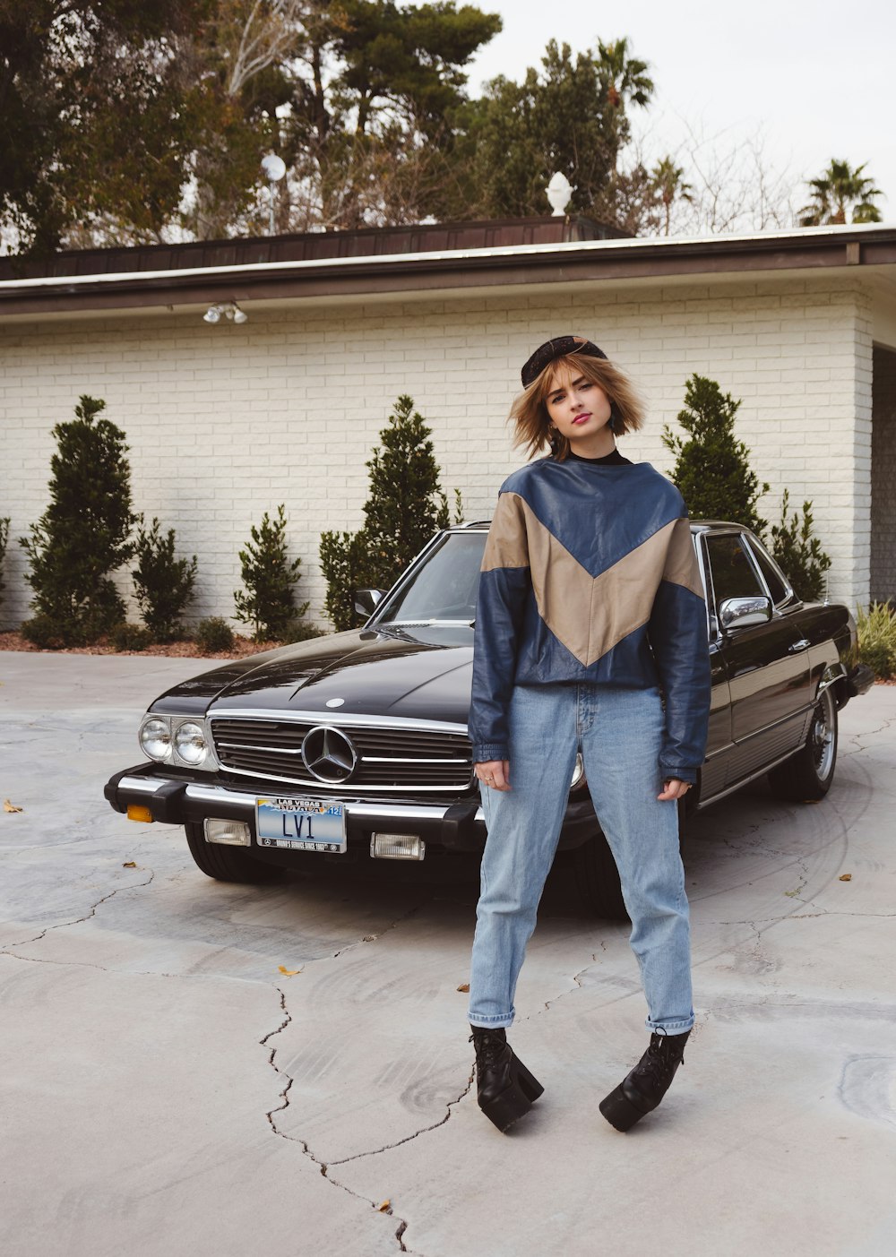 woman standing near black Mercedes-Benz vehicle