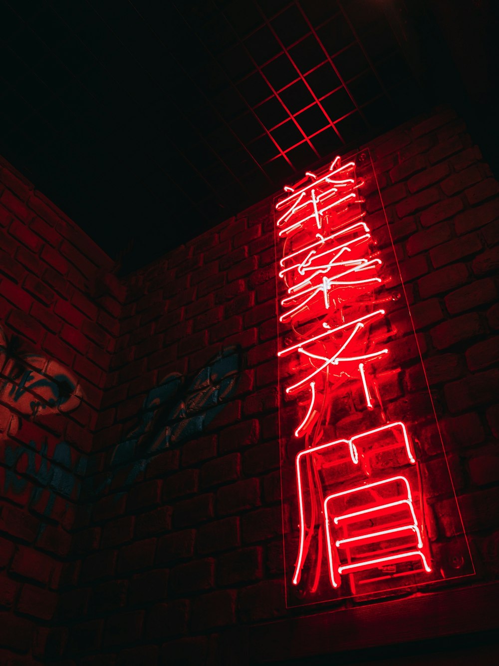 Segnaletica al neon con scritte kanji rosse e bianche