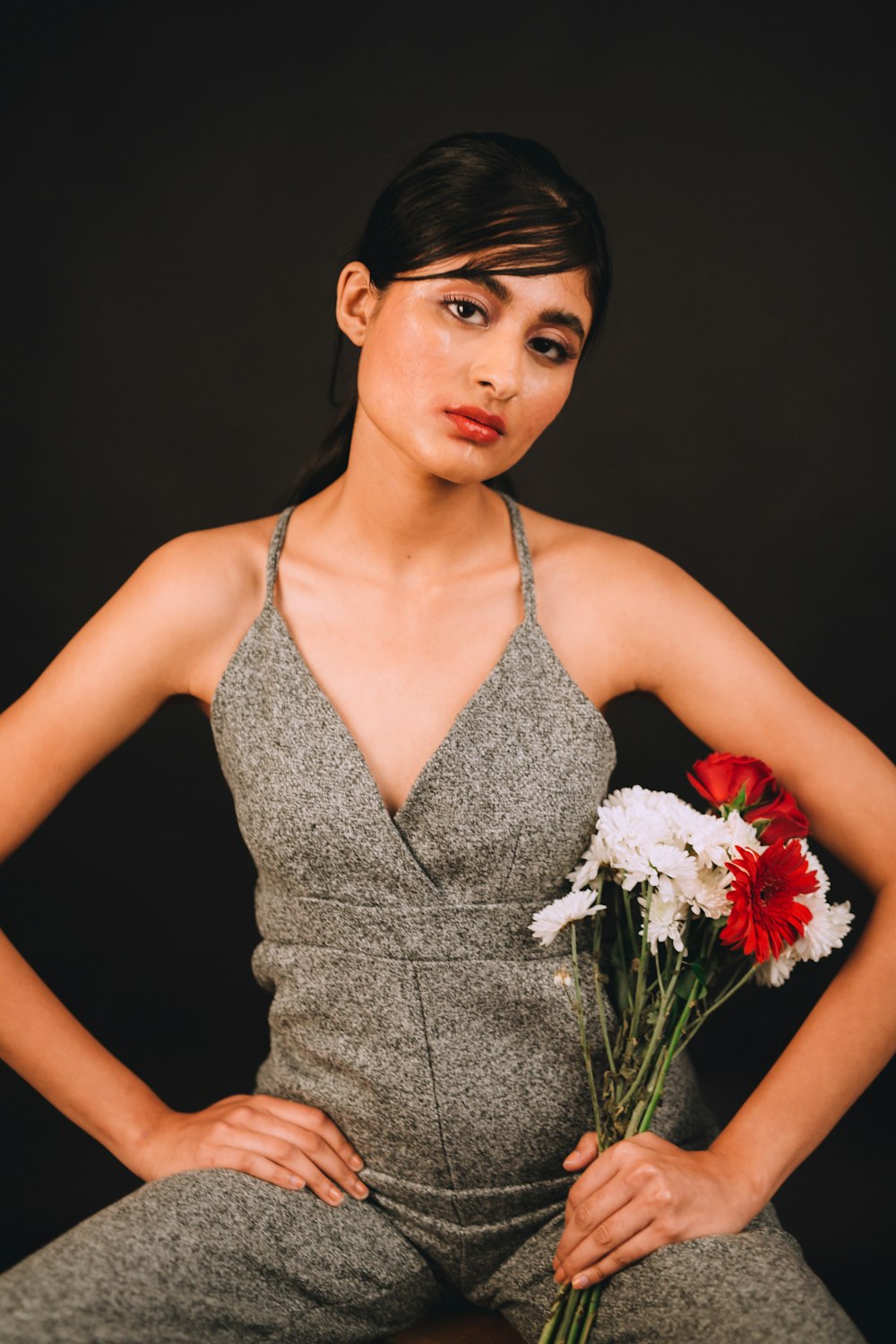 woman holding red-and-white-petaled flower