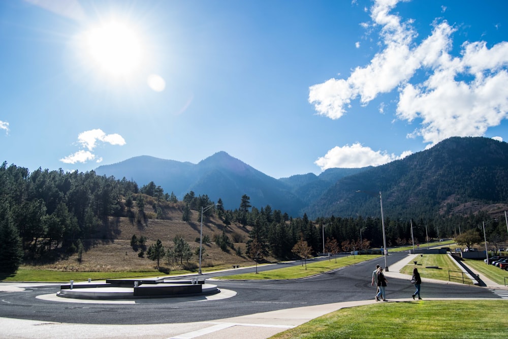 black and gray pavement road towards green mountain ranges