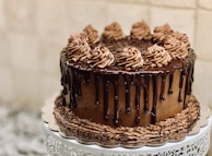 A rich chocolate cake with a glossy ganache and decorative chocolate curls.