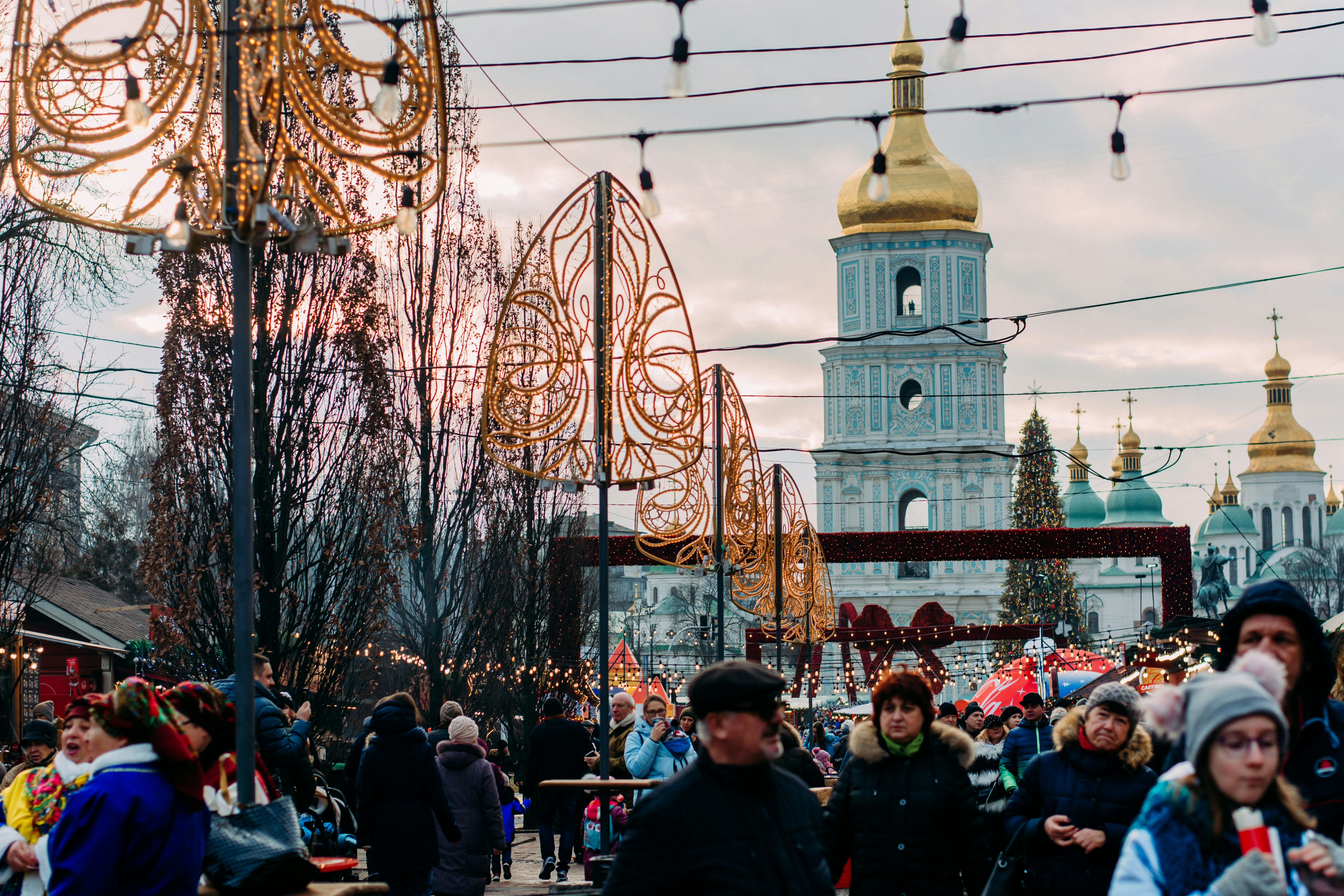 a crowd of people walking down a street next to a tall building