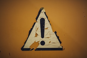 triangular caution sign symbolizing gold ira risks and considerations