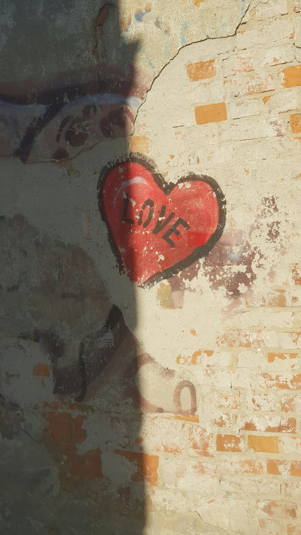 a red heart painted on a brick wall