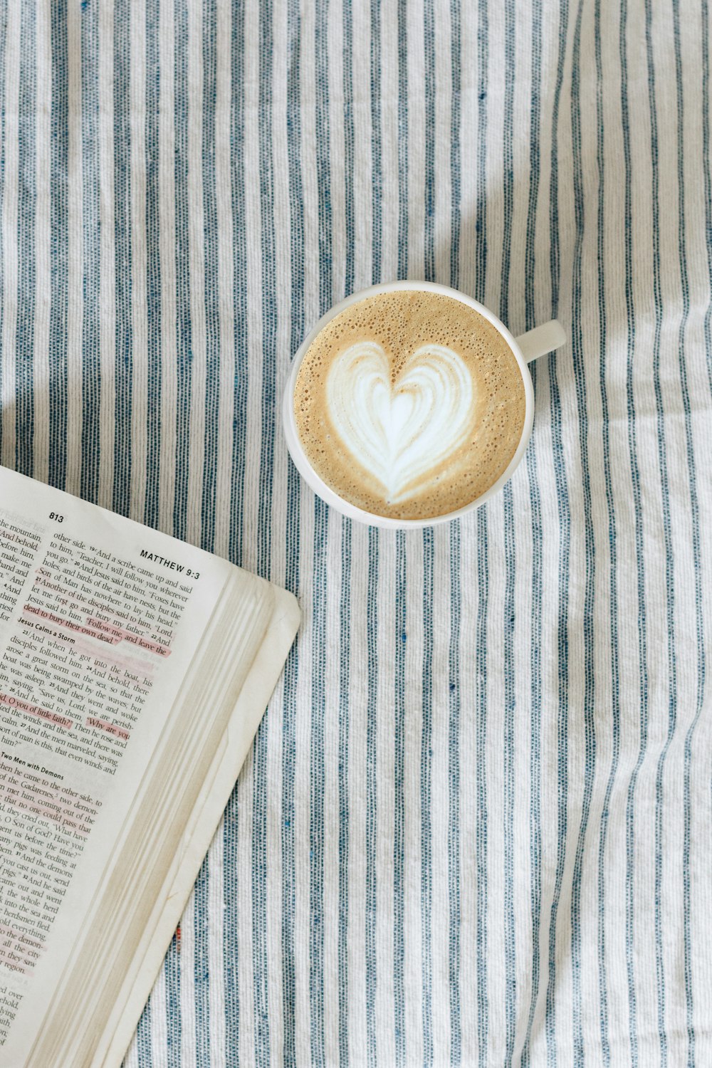 white teacup beside book