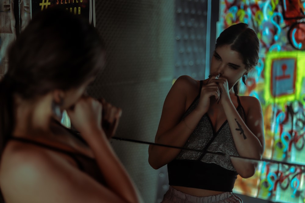 woman in gray crop-top standing in front of mirror