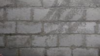 Close-up of fresh mortar being applied to a brick wall by a mason.