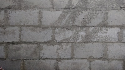 Close-up of fresh mortar being applied to a brick wall by a mason.