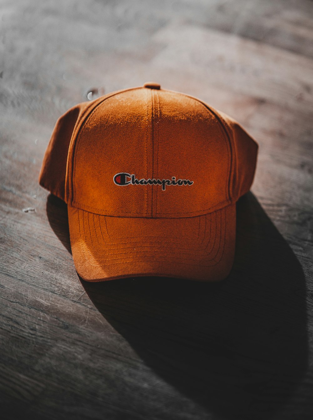 orange Champion curve brimmed cap on gray surface