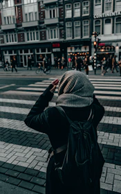 A traveler checking a map with a secure backpack in a bustling city street.
