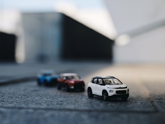 three assorted-color vehicle scale models
