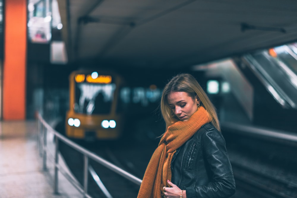 woman wearing black leather jacket and brown scarf