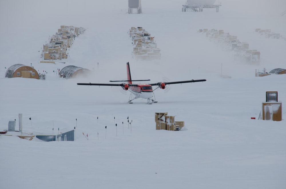 white and brown biplane on snow-covered field