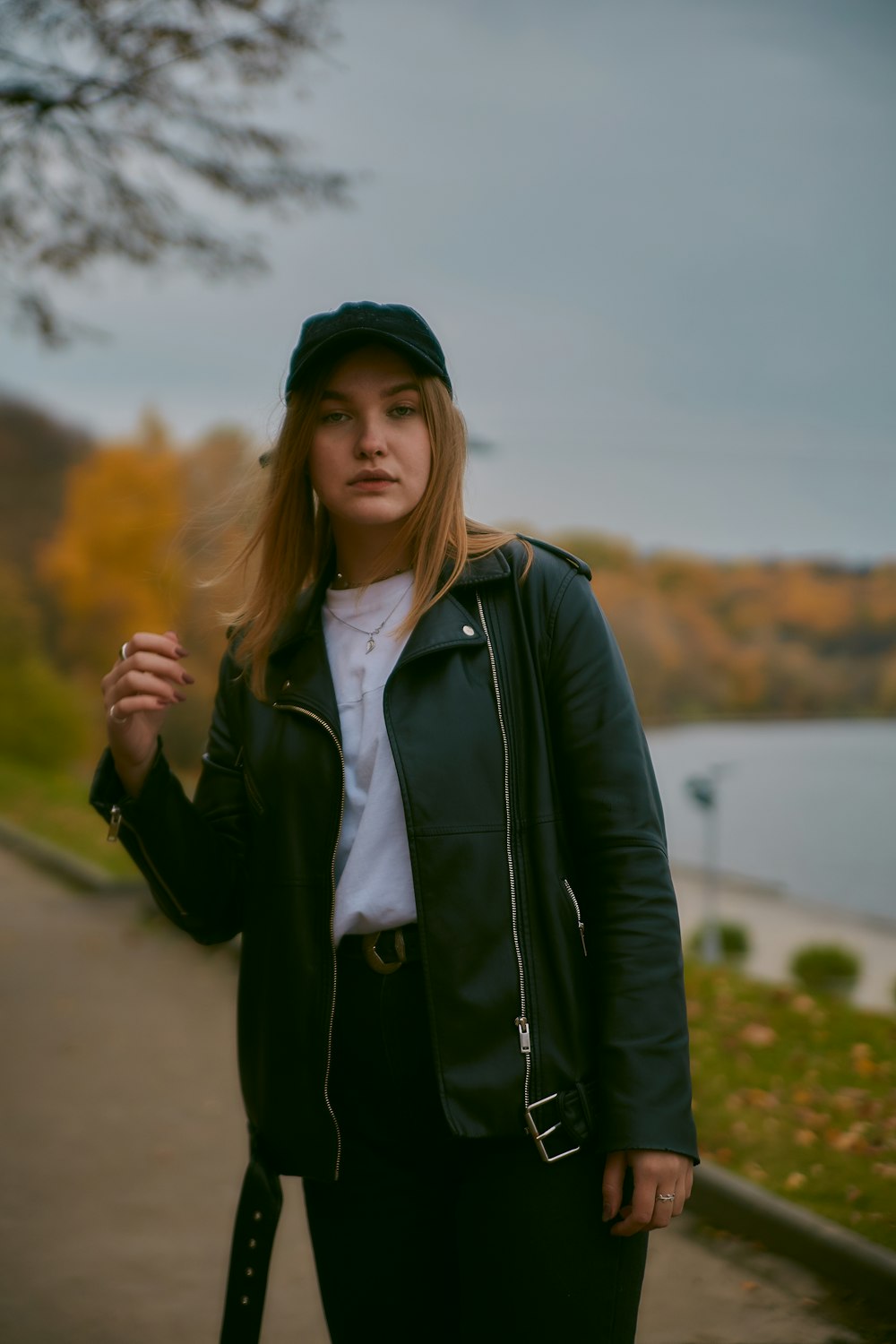 woman in black jacket standing on road