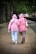 A happy woman in a pastel pink hoodie holding a matching hoodie with her partner.