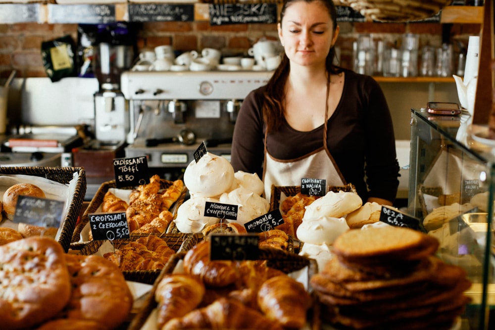 woman on counter near breads