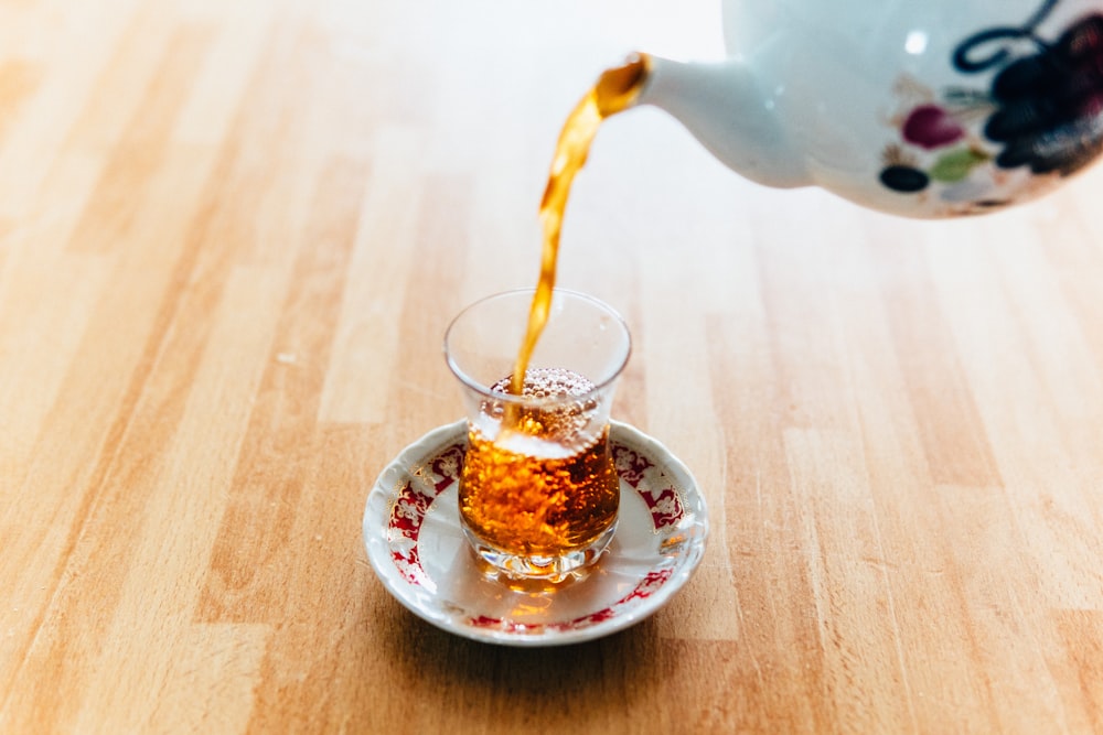 personne versant du thé dans une tasse