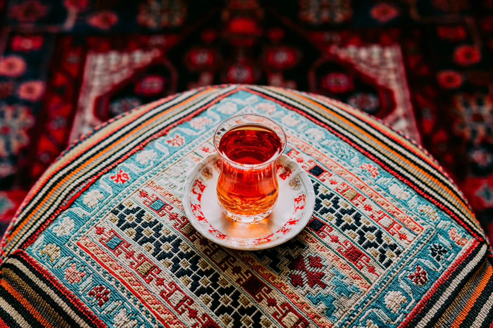 A Turkish tea glass on a patterned carpet