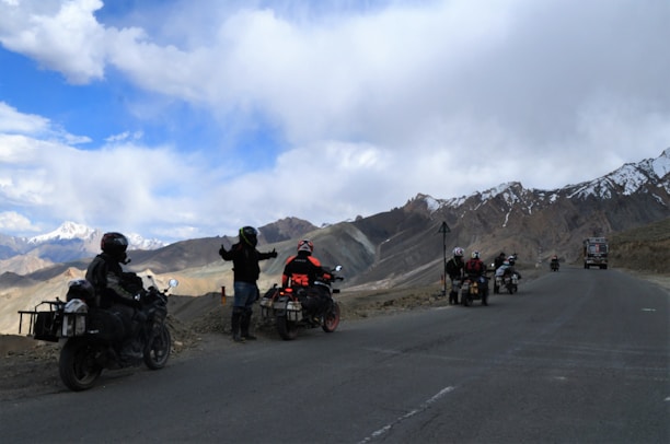 A group of adventure riders setting up camp in the mountains.