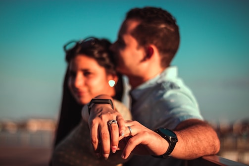 A happy couple admiring their custom rings together in natural light.