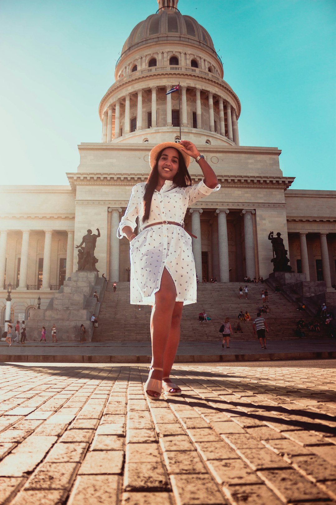 woman in white long-sleeved slit dress standing near structure