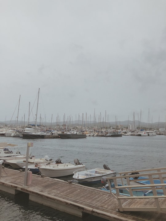 parked powerboats near brown dock under white fogs in Ibiza Spain