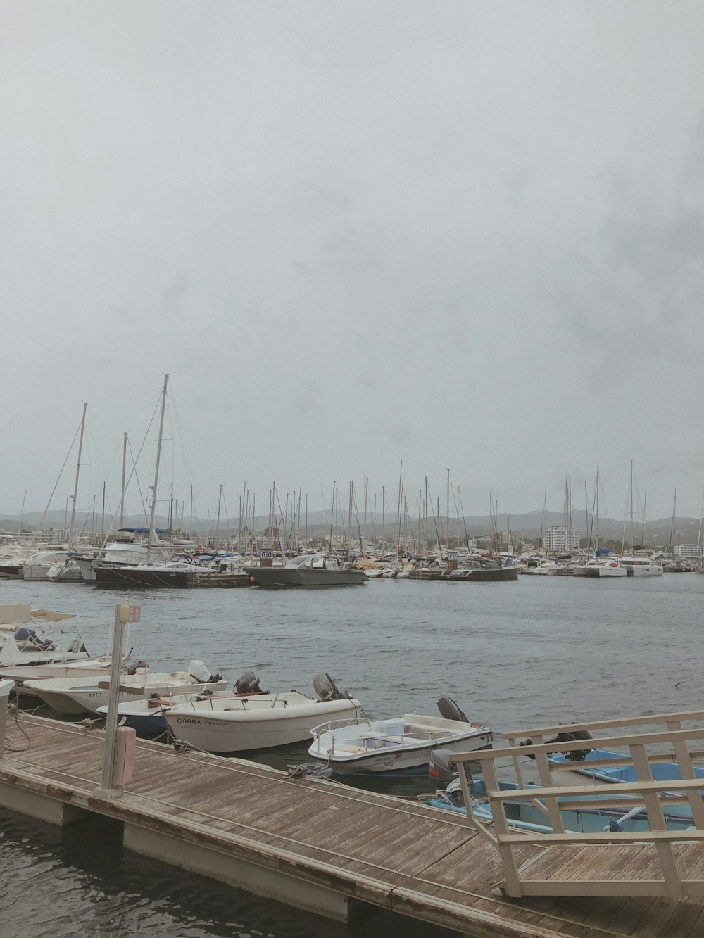 parked powerboats near brown dock under white fogs