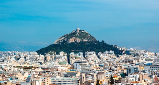 city buildings near black and brown mountain peak in Mount Lycabettus Greece