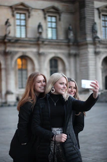 Smiling group taking a selfie in front of a famous cultural landmark