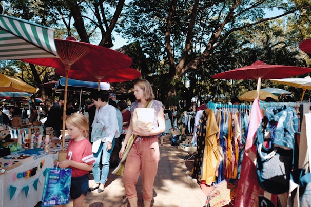 A vibrant street market scene with colorful stalls and people browsing.