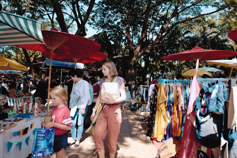 A vibrant street market bustling with locals and travelers under colorful canopies.