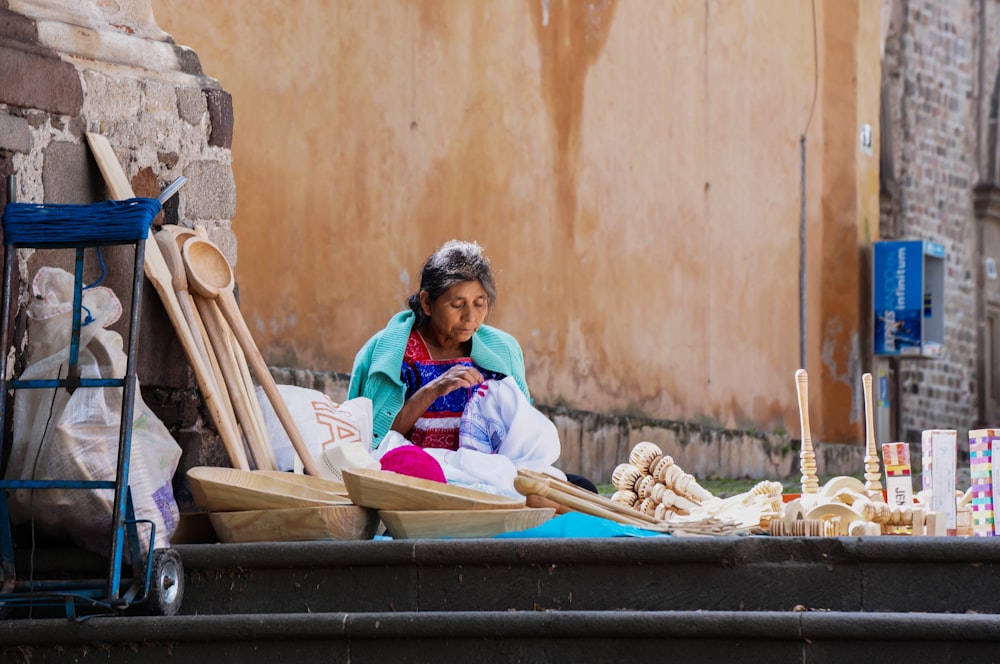 mujer sentada al lado de la calle