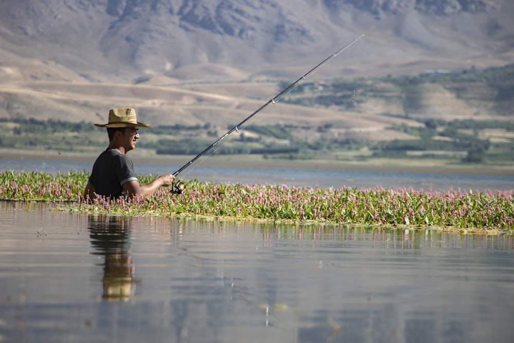 selective focus photography of man doing fishing during daytime
