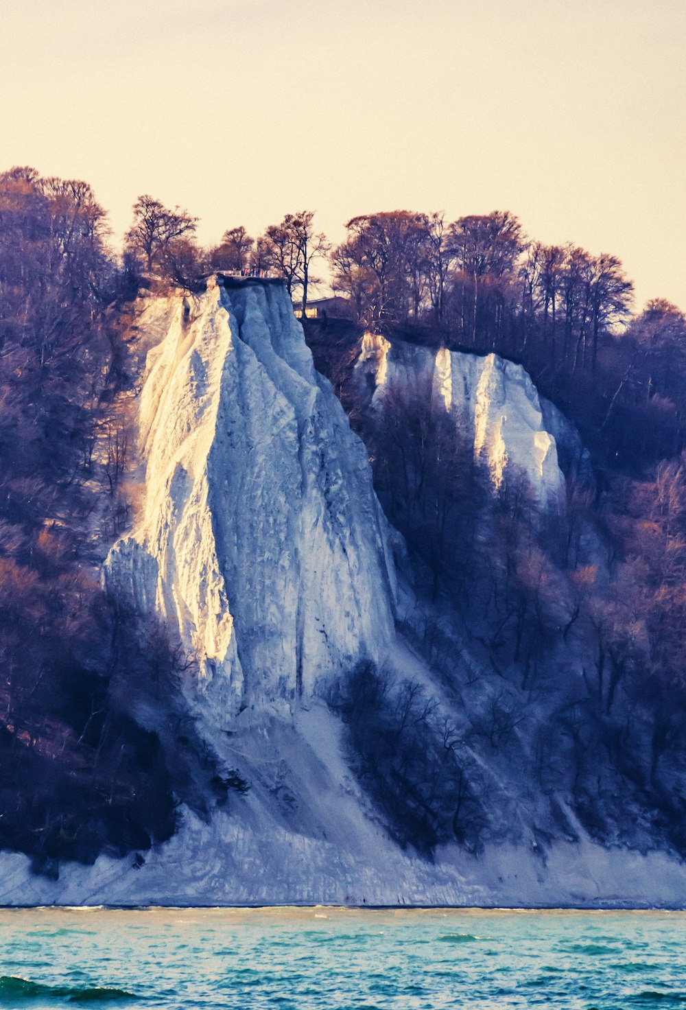 a large white cliff with a tower on top of it