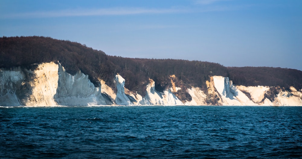 a large body of water with a mountain in the background