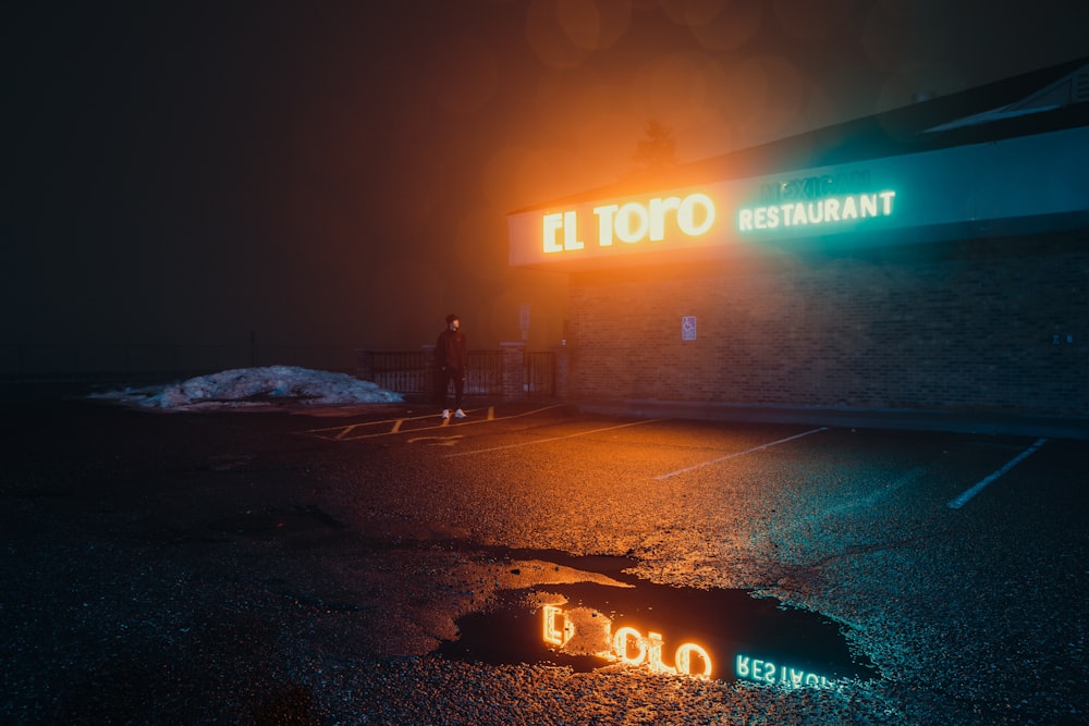 a couple of neon signs that are on the side of a building