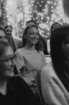 A smiling event planner coordinating a birthday party with happy guests in the background.