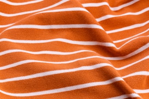Close-up of a rust orange retro diner t-shirt design on cream fabric.