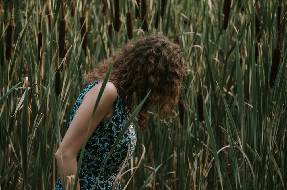 woman in teal and black dress beside grass