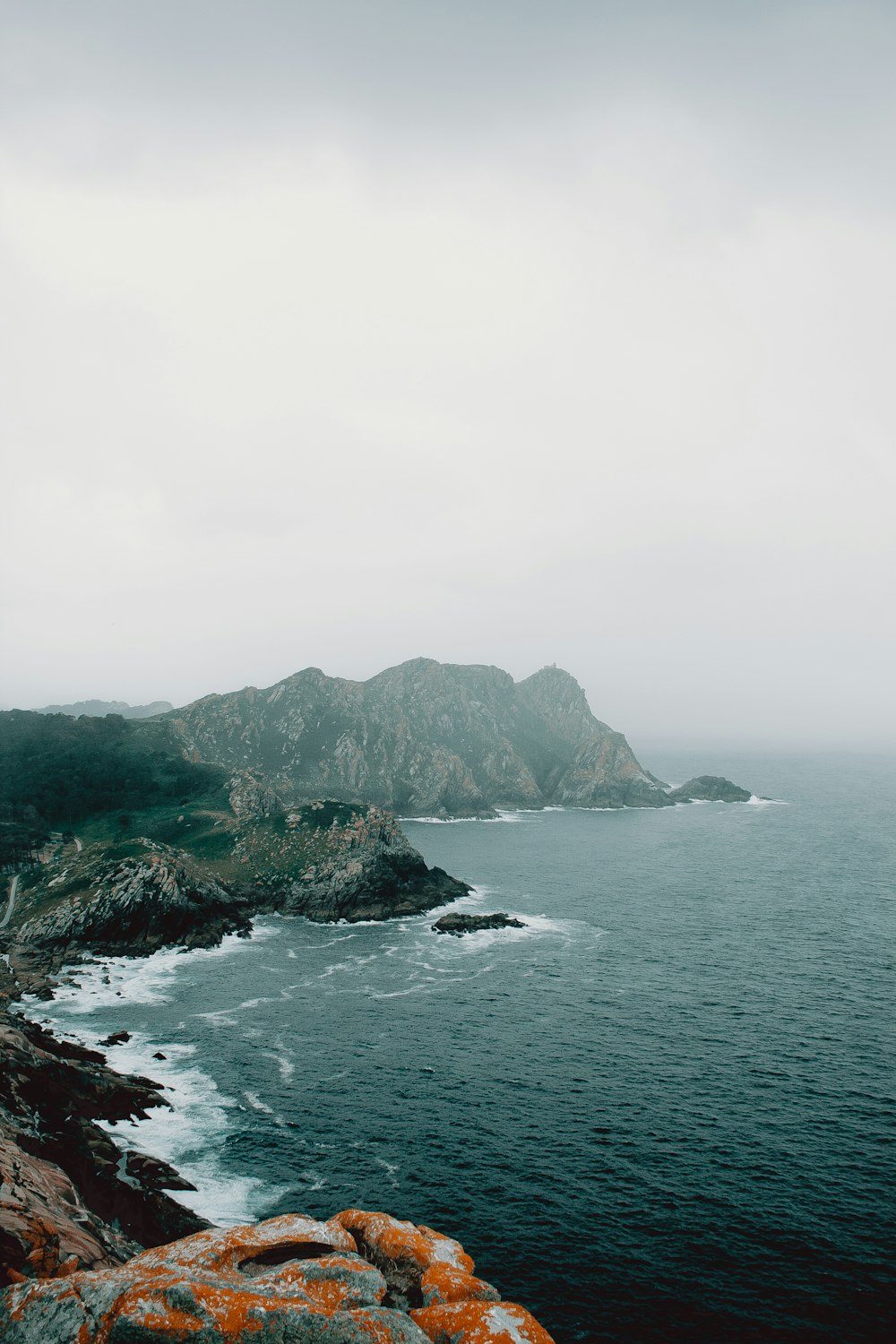 body of water under grey sky