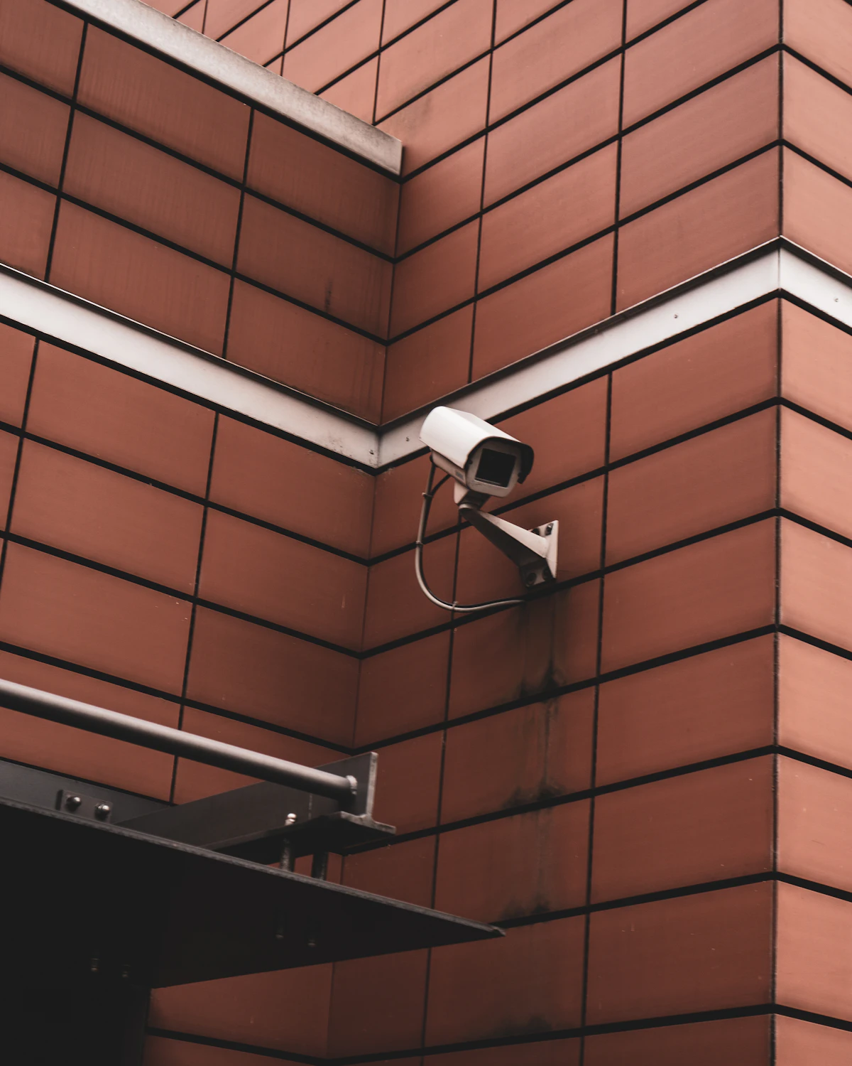 Kamera CCTV putih terpasang di samping dinding