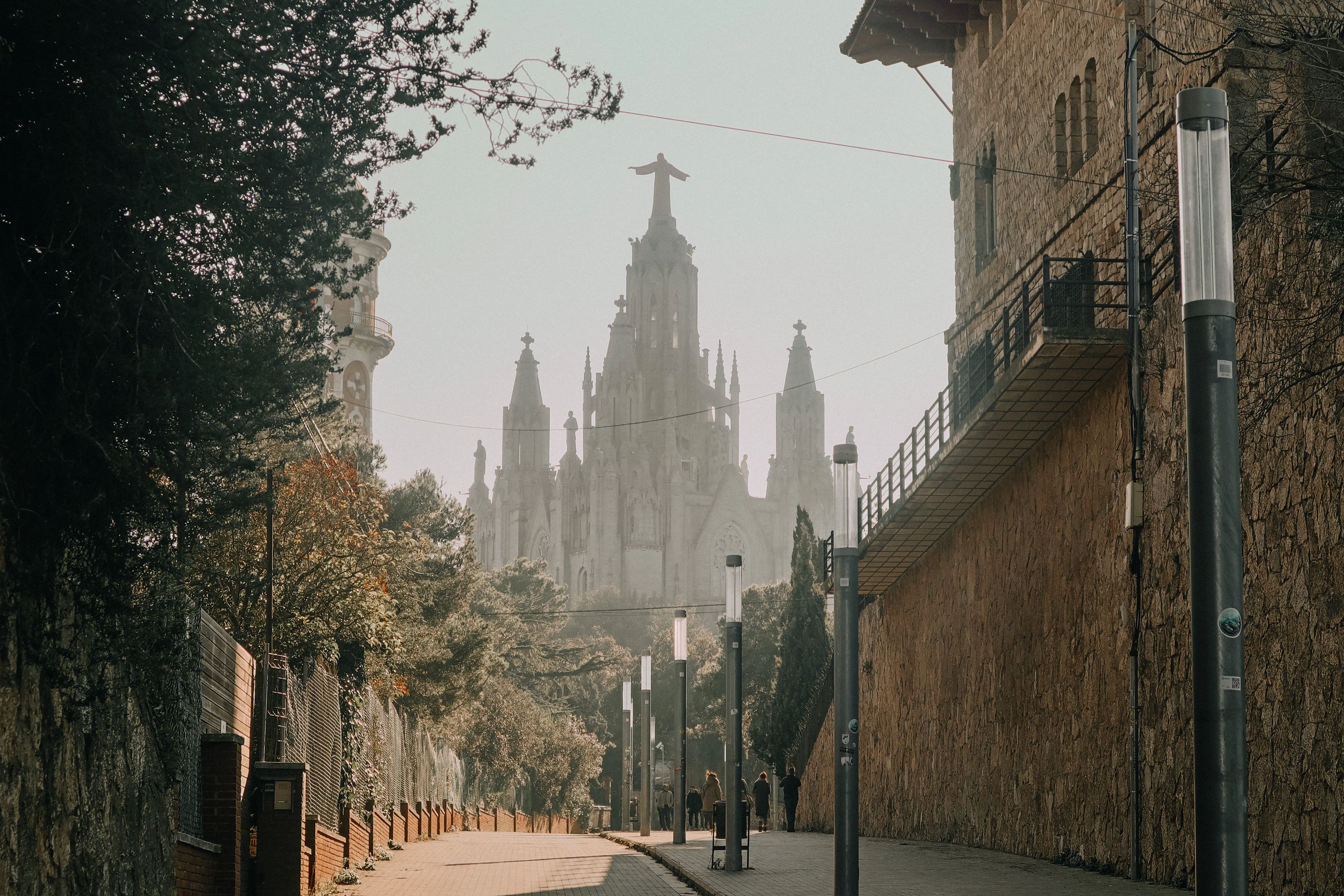A Barcelona street in early light with the spires of the Sagrada Familia closing the view at its end