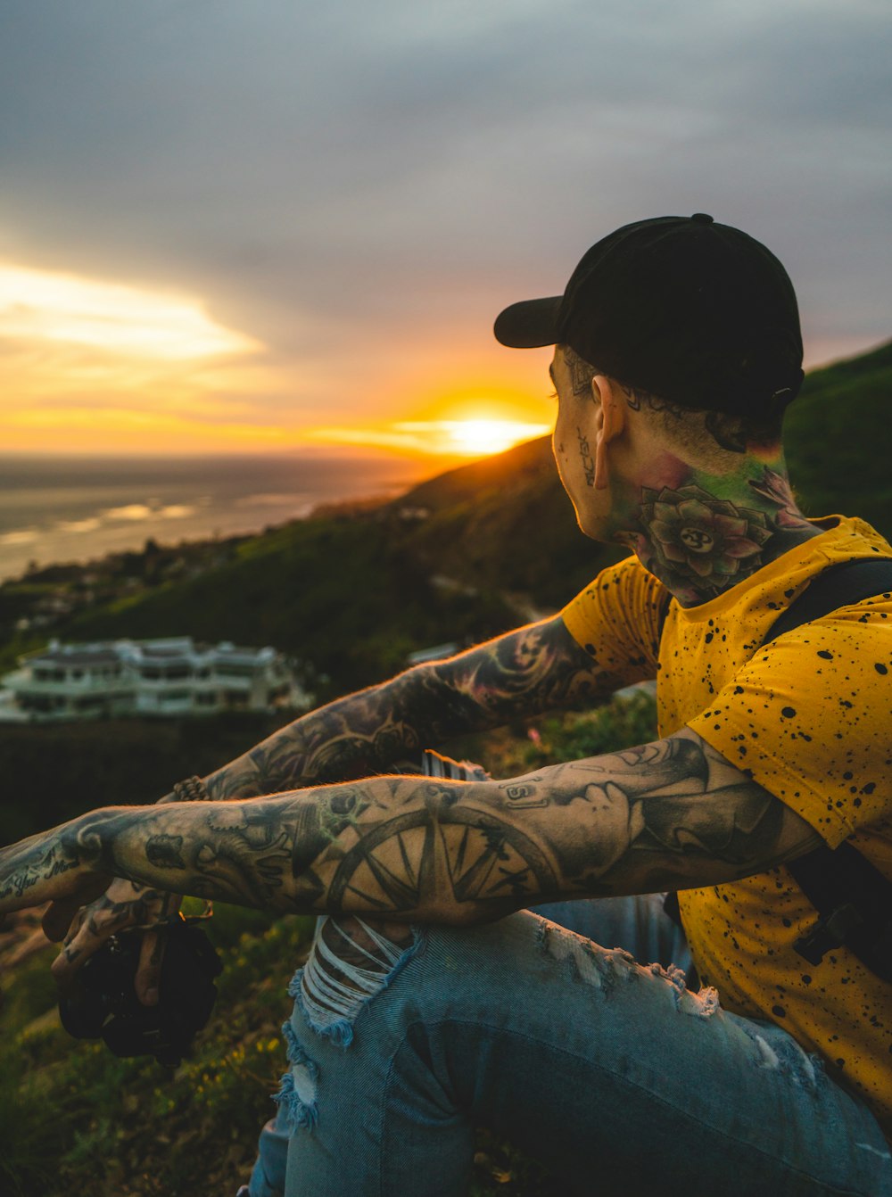 man sitting on hill near cruise ship