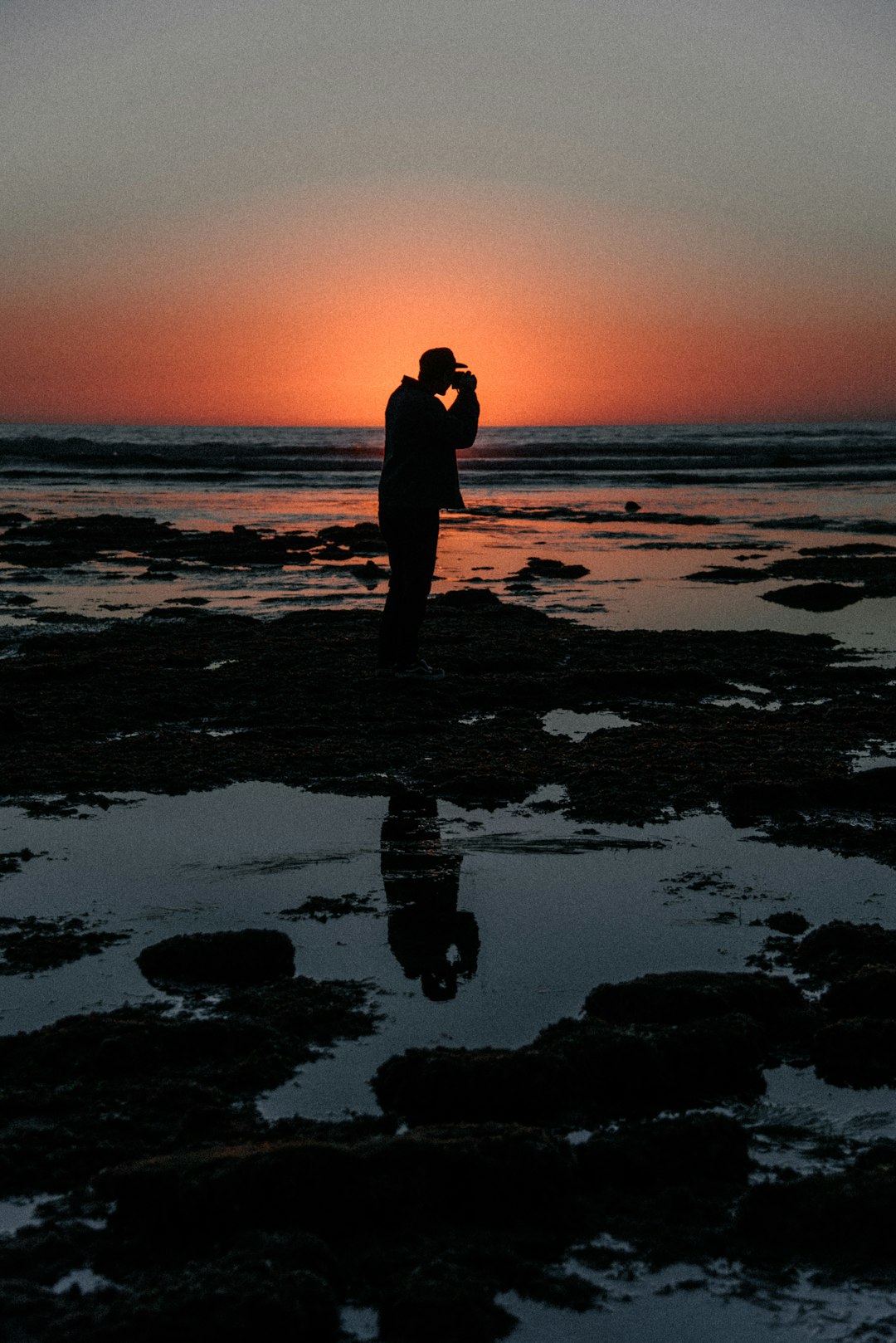 silhouette view of man at the beach during low tide