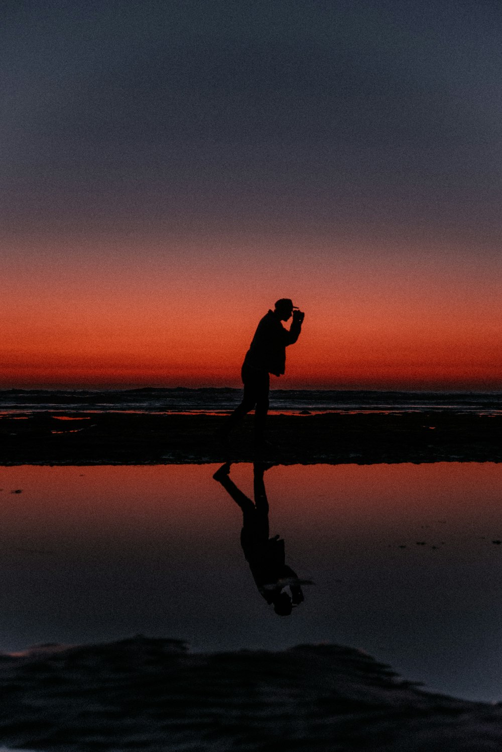 man taking photo silhouette during sunset