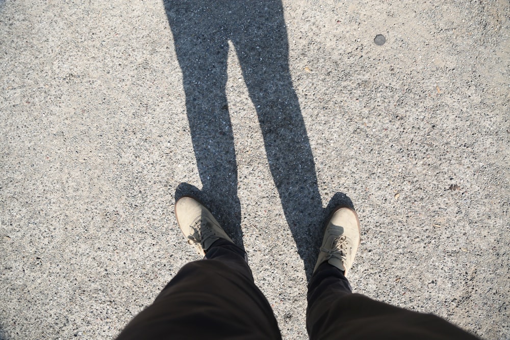 the shadow of a person standing on a sidewalk