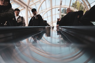 Close-up of a sleek escalator handrail with city skyline in the background at sunset.