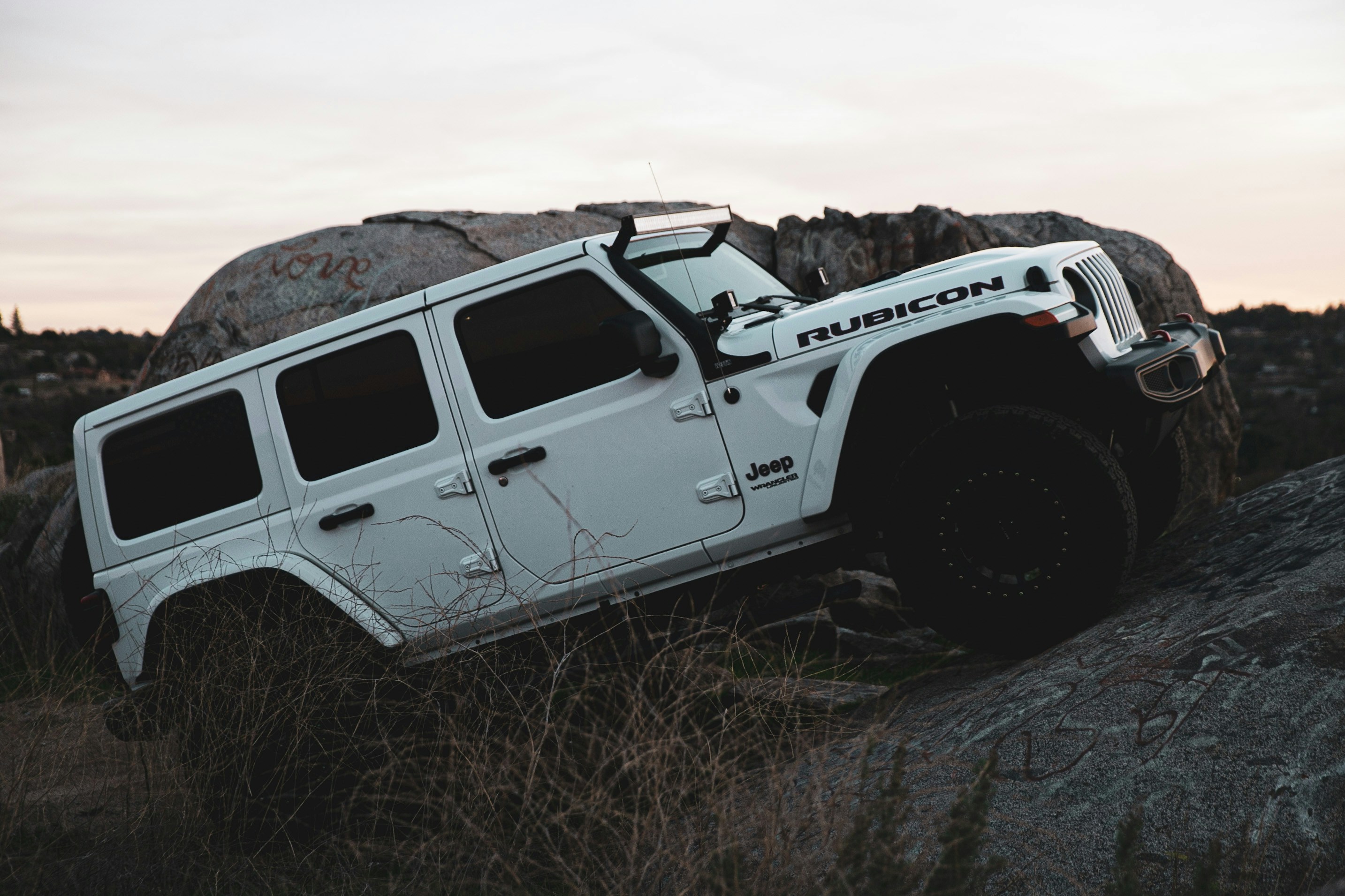 closeup photo of a white jeep climbing hill