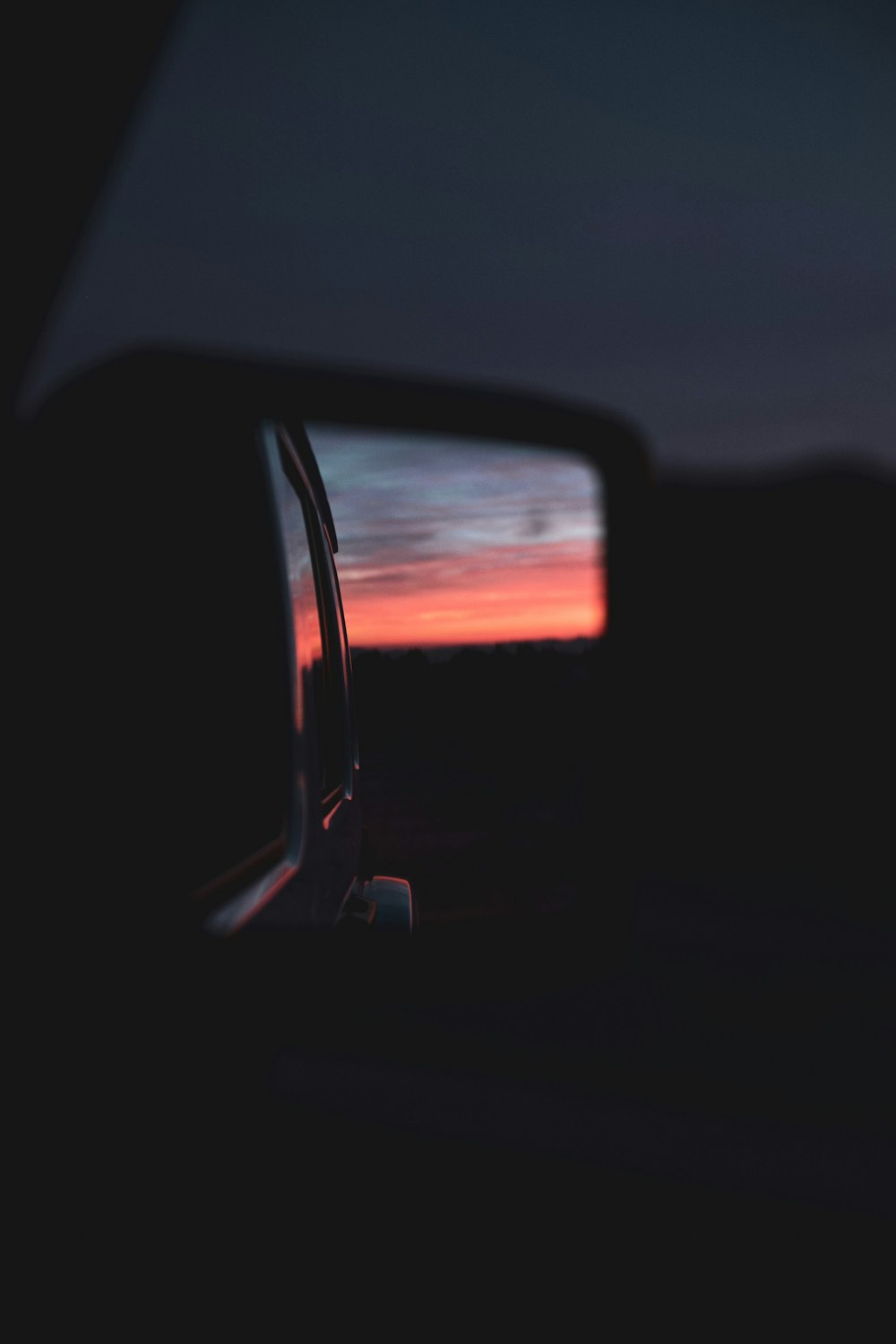 wing mirror reflecting sky during sunset