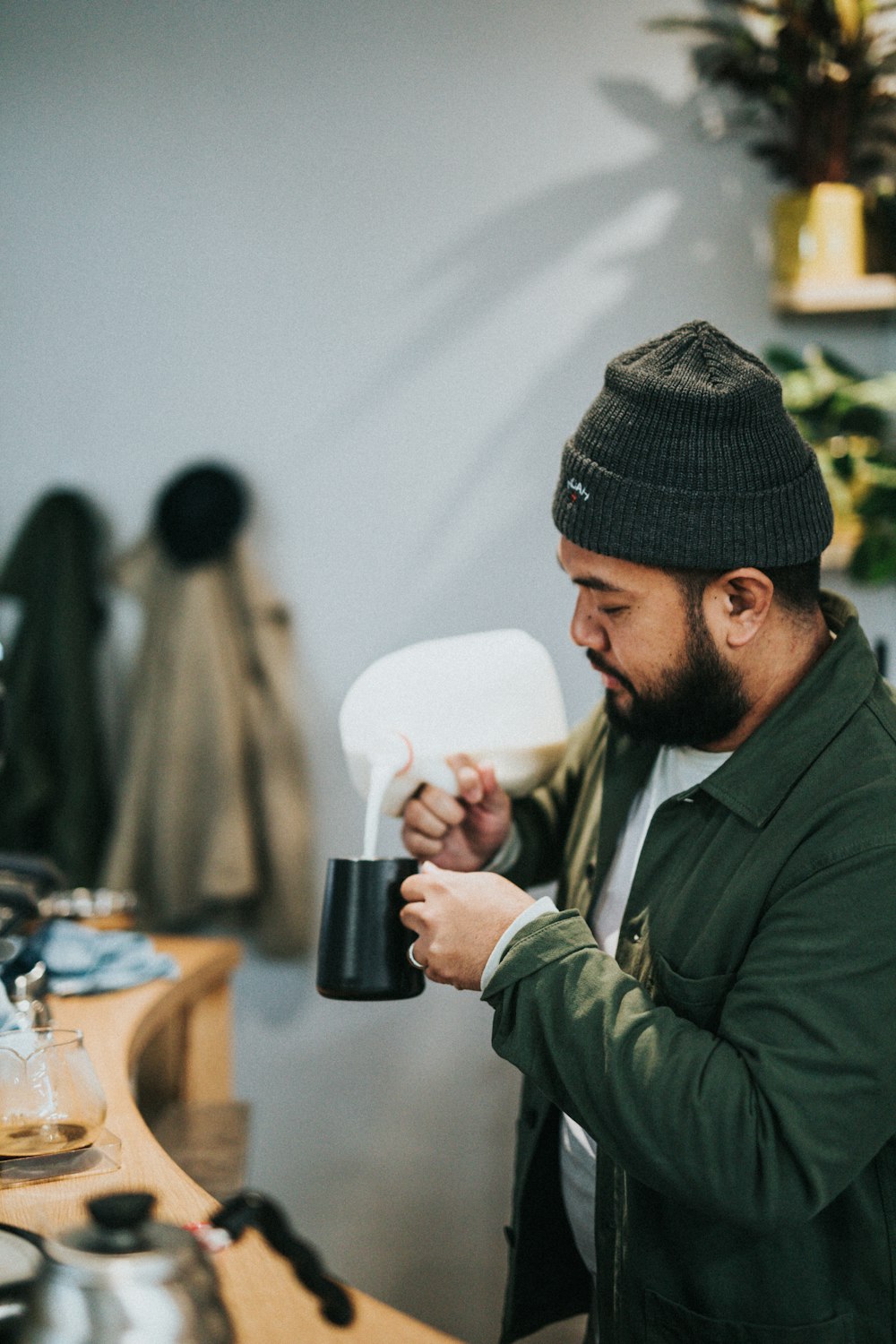 man pouring milk in mug